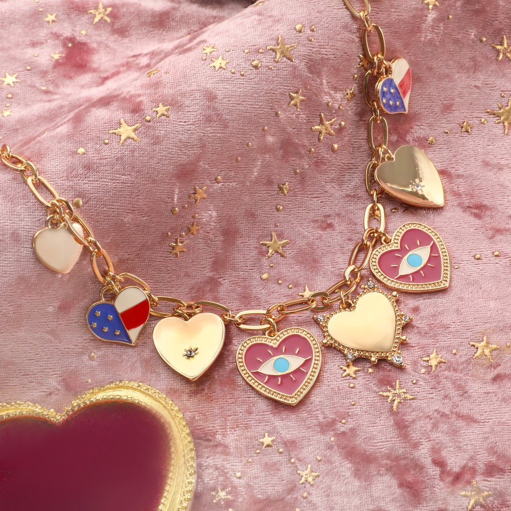 Selenichast Evil Eye Heart Charm Necklace styled on pink velvet with gold stars